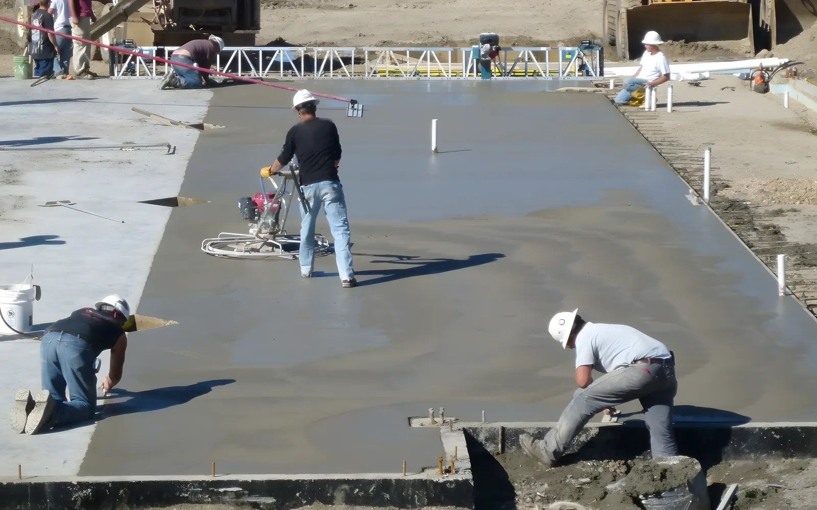 Contractors power floating a large freshly placed concrete floor slab