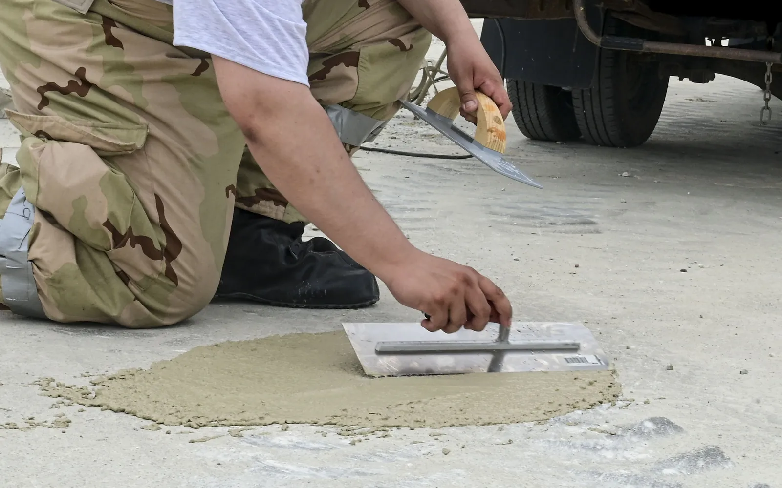 Patch repair mortar being finished with a steel trowel on a concrete slab