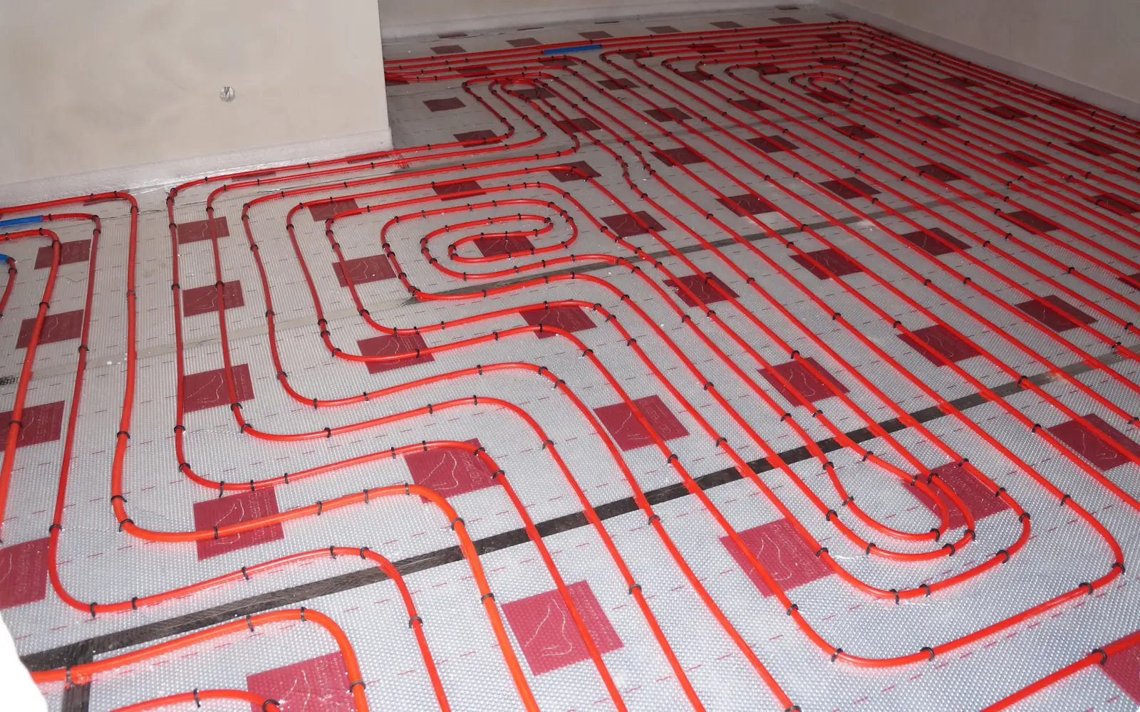 Underfloor heating pipes laid out on insulation ready for screeding